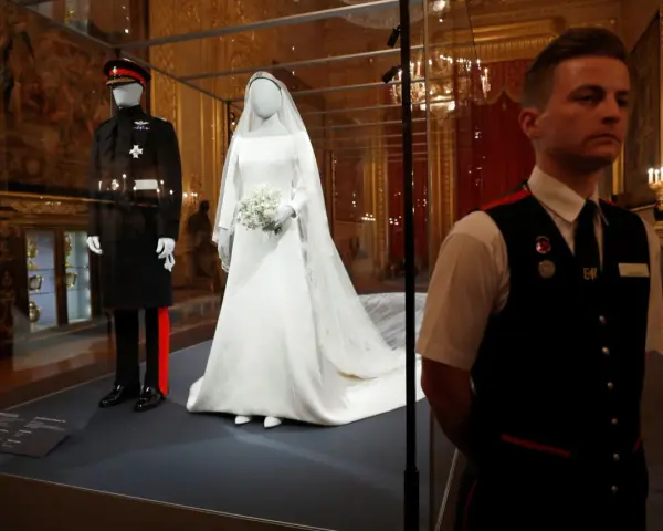 La robe mariée Meghan Markle, d'une élégance intemporelle, est exposée aux côtés de l'uniforme du Prince Harry.