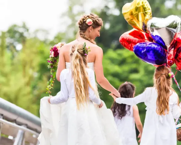 Mariée et enfants d'honneur, joyeux jeux d'enfants pour un mariage, avec des ballons en forme de cœur.