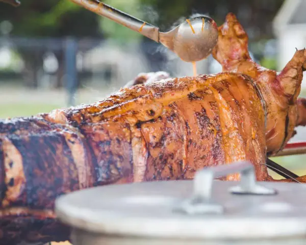 Un cochon à la broche doré et juteux, arrosé d'une sauce savoureuse. Un accompagnement parfait pour une fête mémorable.