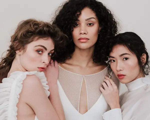 Trois femmes aux visages lumineux, prêtes pour un soin visage avant mariage. Leur peau est radieuse, leurs regards doux.