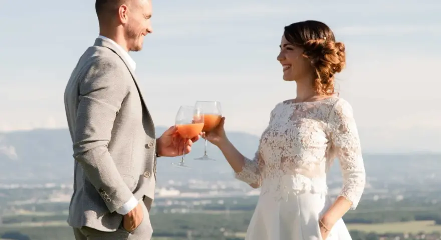 Un couple marié trinque avec des cocktails fruités, une belle quantité de soft pour un mariage en plein air.