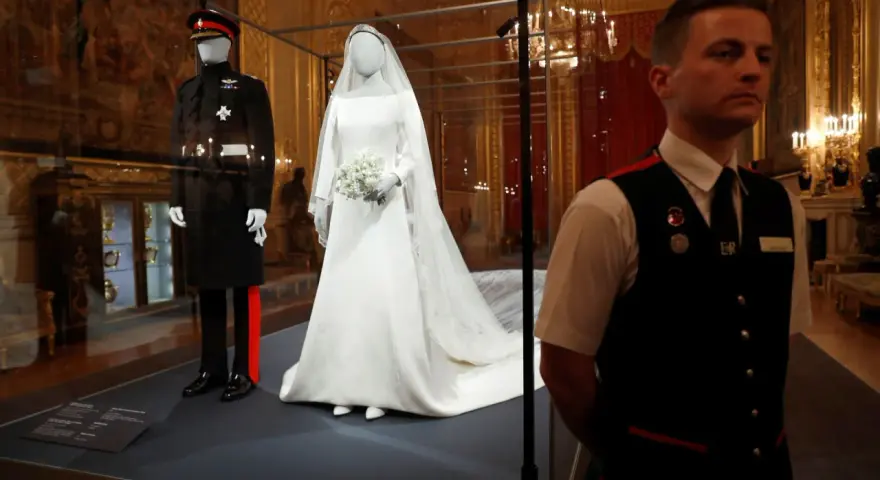 La robe mariée Meghan Markle, d'une élégance intemporelle, est exposée aux côtés de l'uniforme du Prince Harry.
