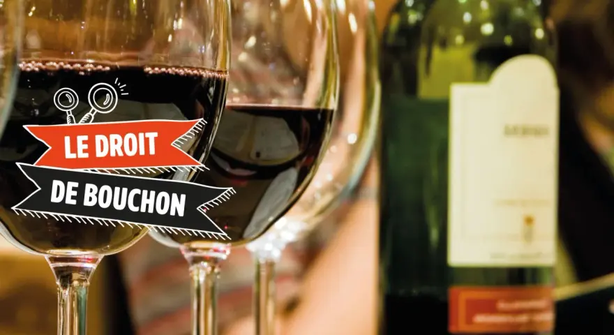Verres de vin rouge, une bouteille et une bannière "Le Droit de Bouchon". Le prix est une question à explorer.
