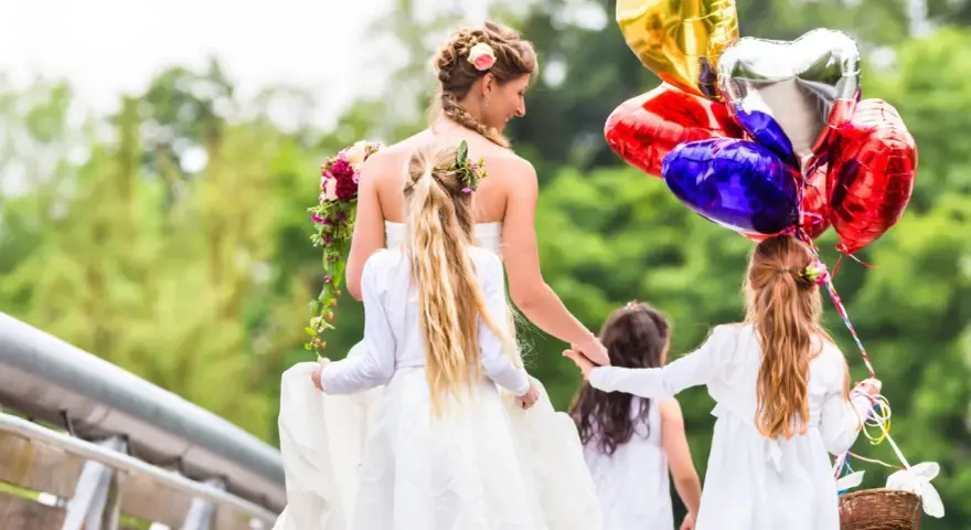 Mariée et enfants d'honneur, joyeux jeux d'enfants pour un mariage, avec des ballons en forme de cœur.