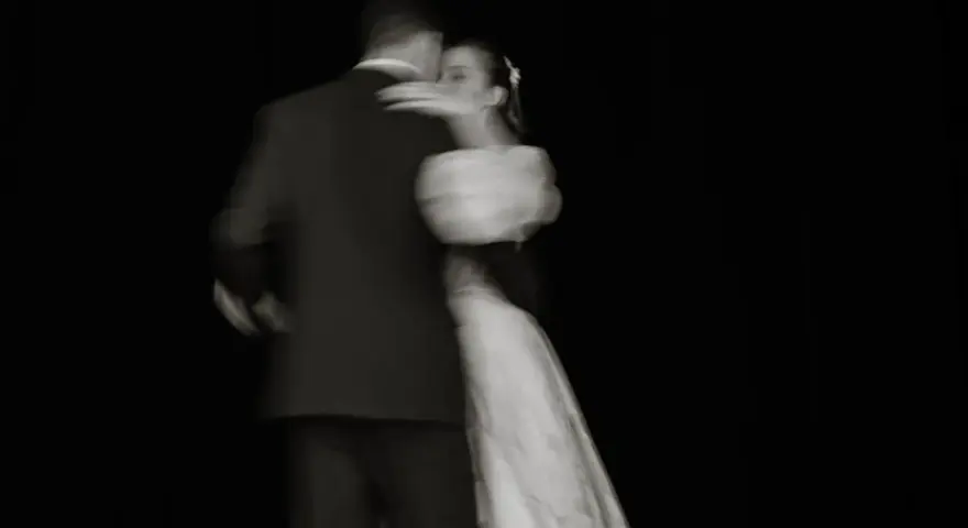 Un couple danse lors de l'ouverture de bal de leur mariage, le mouvement capturé dans un flou artistique.