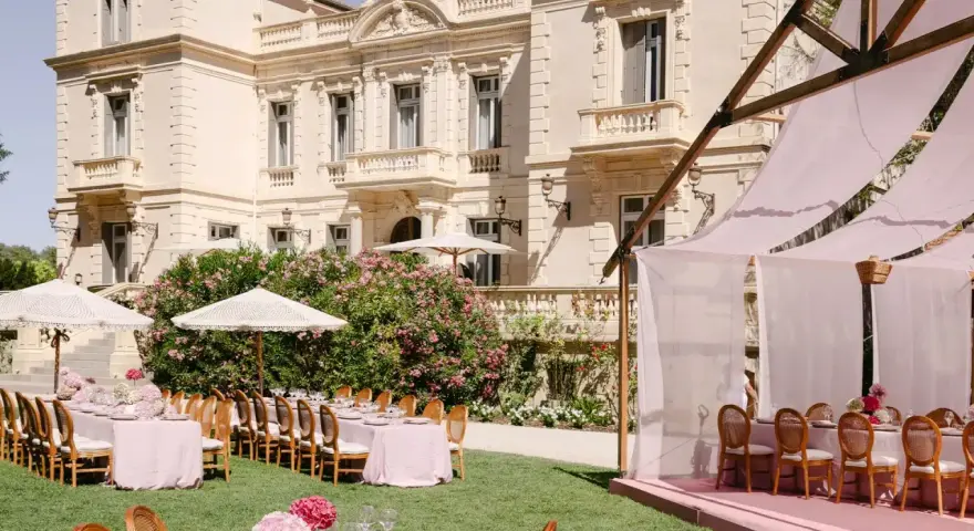 Magnifique **organisation cérémonie laïque** dans un jardin, avec tables dressées et château en arrière-plan.