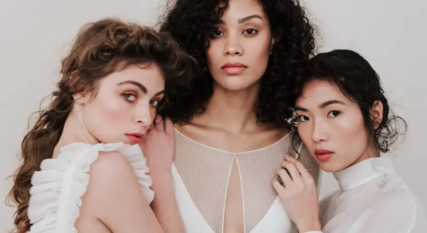 Trois femmes aux visages lumineux, prêtes pour un soin visage avant mariage. Leur peau est radieuse, leurs regards doux.