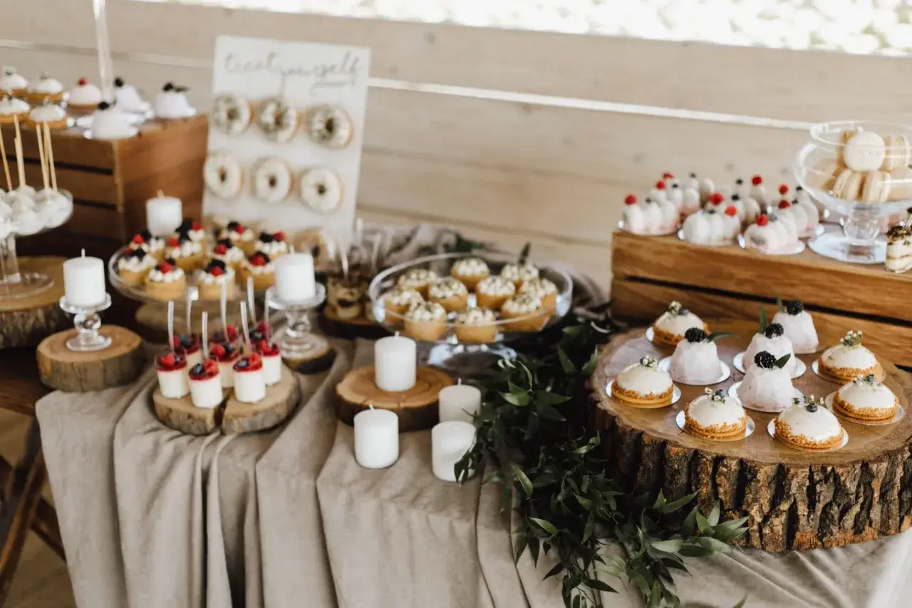 Un buffet de desserts pour un repas mariage : mini-g&acirc;teaux, donuts, macarons et verrines.