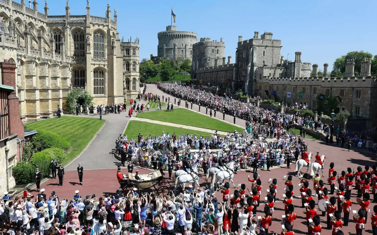 Cérémonie du mariage de Harry et Meghan à Windsor. Une foule immense acclame le couple royal dans une calèche, entourée de gardes et de la chapelle Saint-Georges.