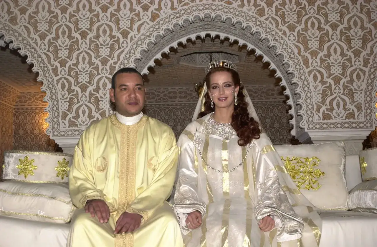 Un couple royal célèbre son mariage en islam, parés de tenues traditionnelles ornées d'or, sous une arche décorée.