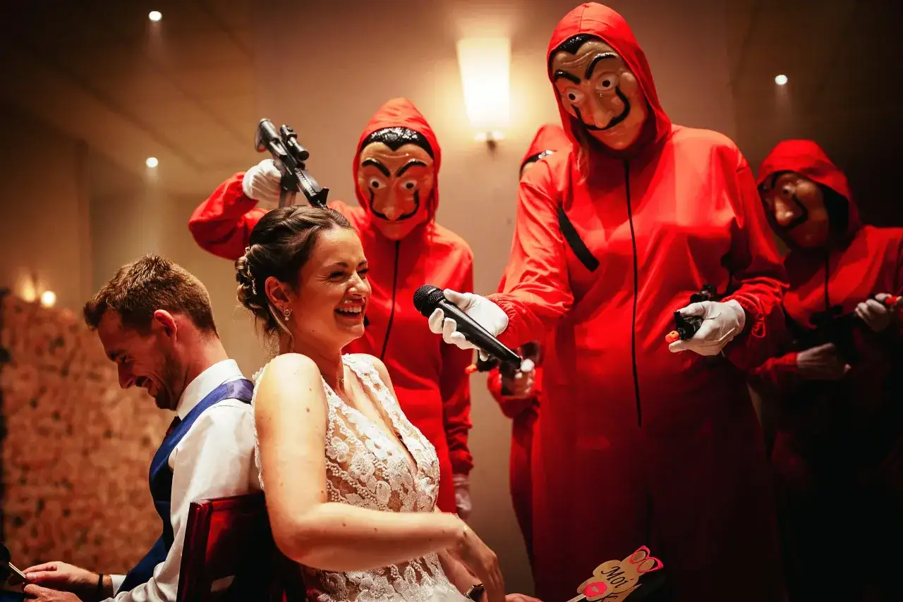 Mariage déjanté : la mariée rit aux éclats pendant un quizz mariage marrant, entourée d'invités masqués façon